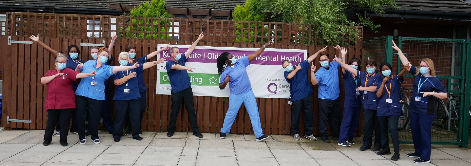 staff from social enterprise healthcare provider Navigo in front of a sign saying they are rated outstanding by the Care Quality Commission
