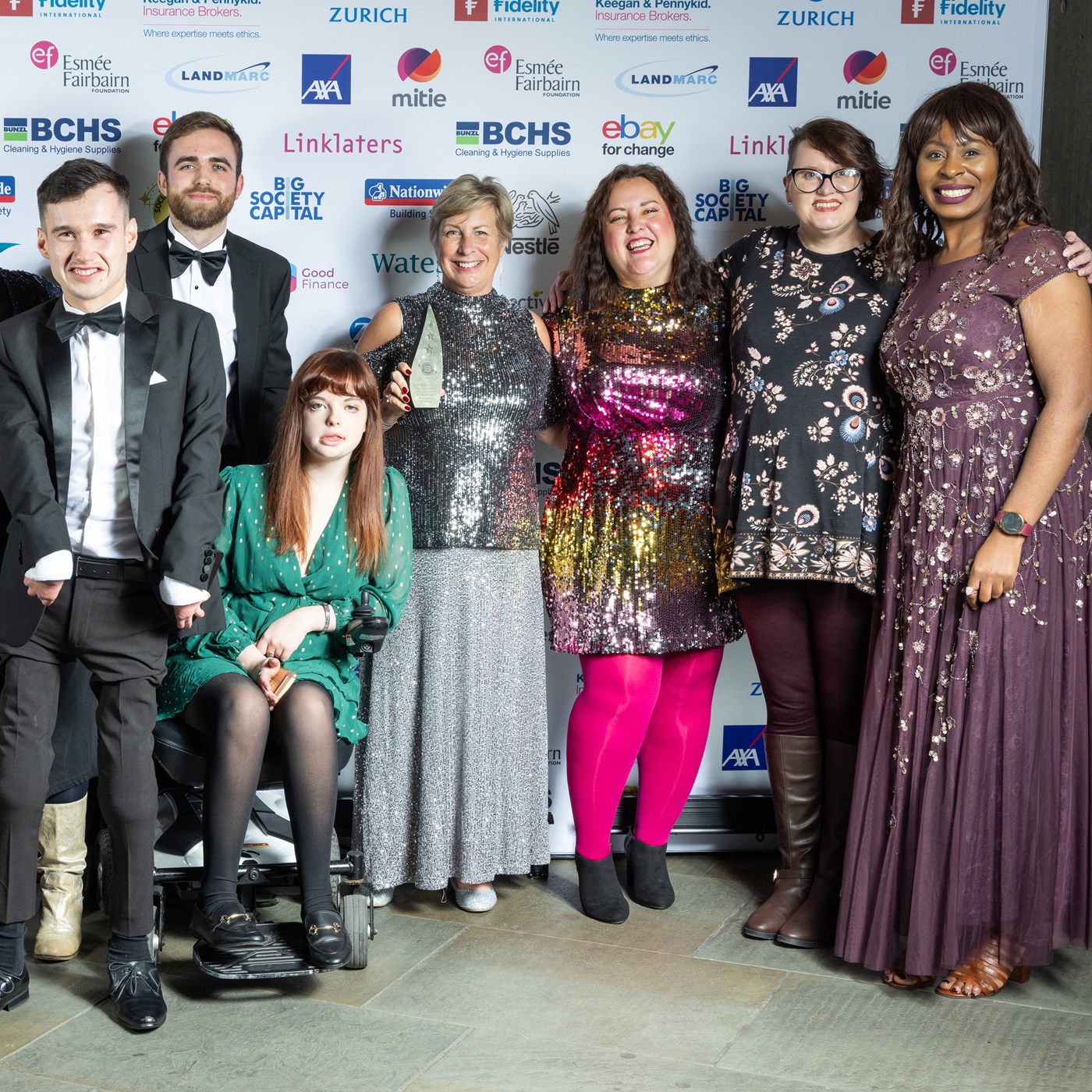 The Evenbreak Team in front of a pap board containing sponsor logos